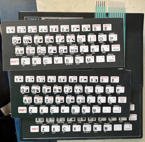 The new ZX81 keyboard membrane and the sticker cover that turns it into a TS1000 keyboard. From bottom to top: original keyboard, new keyboard, keyboard overlay sticker.