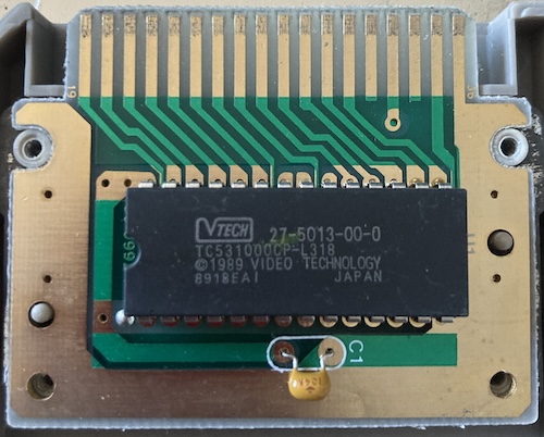 A mask ROM IC and one solitary capacitor are exposed. The part number is VTECH 23-5013-00-0, the Toshiba part is TC531000CP-L318. Date code 89/18, made in Japan.