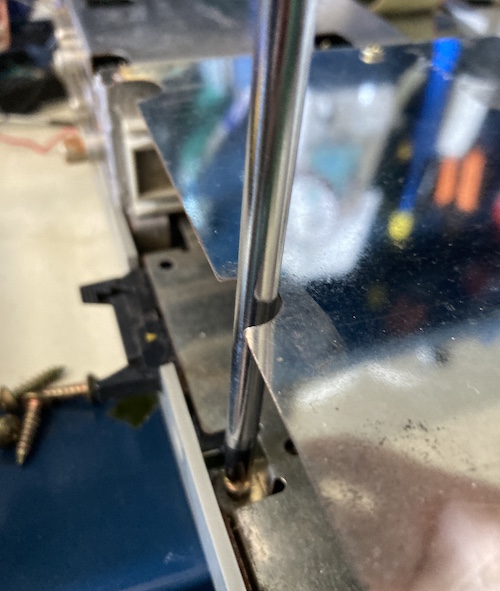 A screwdriver blade can fit right into the holes left for easy unscrewing of the card cage.