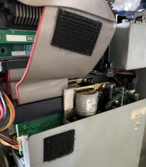 The floppy drive ribbon cable has stick-on velcro so it can adhere tightly to the floppy drive shell.