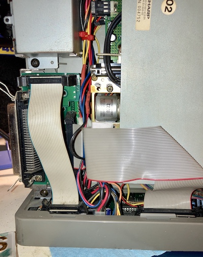 Two ribbon cables (one for SASI, one for floppy), wires for speaker, floppy front panel buttons, IO board power, main board power, floppy power, etc are all crammed into a tiny space between the foot of the power supply, the floppy drives, and the SASI breakout board.