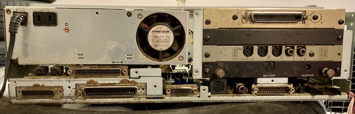 The rear of the computer, after the rear panel is removed. There's lots of rust and gunk all over the place.