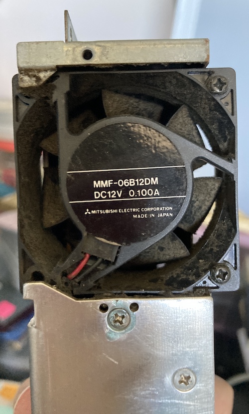The power supply fan is choked solid with grime.