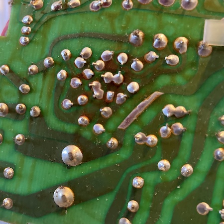 Some brown-stained traces and dull-looking solder joints in the middle of the PCB.
