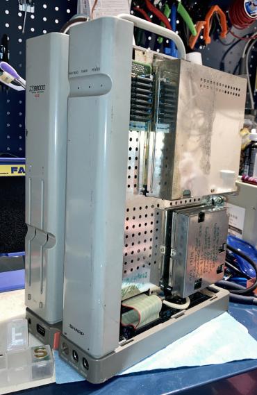 The X68000 is sitting on my desk with no sides installed. The handle is up.